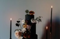a matte black textural wedding cake with lush moody blooms for decor
