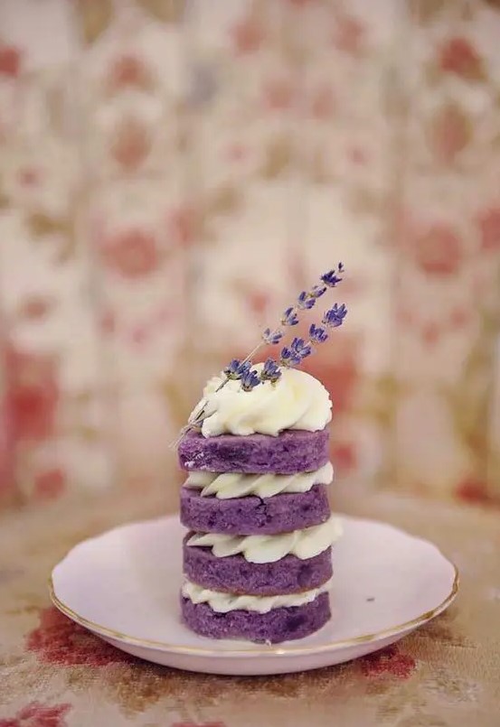 a mini naked lavender wedding cake with whipped cream and lavender on top for a summer wedding