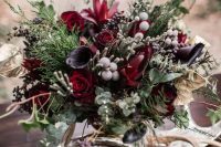 a moody Halloween centerpiece with deep purple and burgundy blooms, berries, textural greenery and foliage