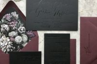 a moody wedding invitation suite in black and plum, with dark floral lining and pressed calligraphy