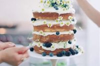 a naked summer cake with daisies, blueberries and blackberries for a boho or country summer wedding
