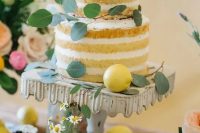 a naked wedding cake decorated with eucalyptus, lemons and a fig for a Mediterranean wedding