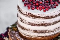 a naked wedding cake topped with fresh cranberry and a sugar deer is a gorgeous option for Christmas