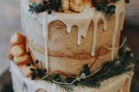 a naked wedding cake with creamy drip, greenery, berries and apple cider donuts for a fall rustic wedding