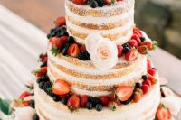 a naked wedding cake with fresh berries and blush blooms is a nice option for a summer rustic wedding