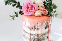 a naked wedding cake with pink drip, vanilla macarons, fresh blooms and foliage