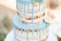 a naked wedding cake with powder blue drip and blush peonies looks very spring-like