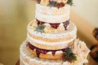 a naked wedding cake with raspberry mousse inside, blush, cream and orange blooms and thistles