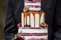 a red velvet partly naked wedding cake with caramel drip, with purple callas and fresh fruit is a decadent idea for a fall vineyard wedding