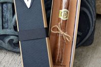a simple and budget-friendly groomsmen gift is a cigar in a box that is decorated with a tuxedo