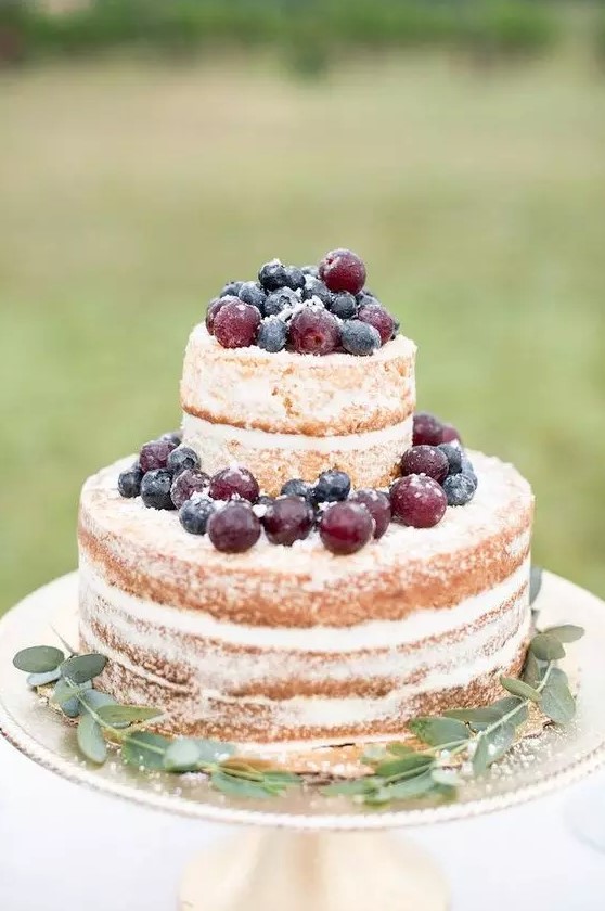 a simple and cool naked wedding cake topped with fresh blueberries and grapes is a great idea for a fall vineyard wedding