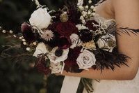 a sophisticated Halloween wedding bouquet with burgundy, white blooms, grasses, berries and some foliage