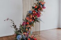 a striking indoor wedding backdrop of a wooden plank stand and a lushfloral installation placed asymmetrically