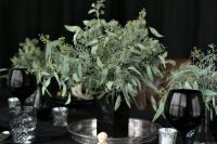 a stylish and catchy modern wedding centerpiece of a black square vase and fresh eucalyptus is a fresh idea for a Halloween wedding