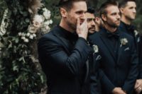 a total black look for the groom with a three-piece suit, a bow tie and the groomsmen wearing the same