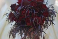 a unique Halloween wedding bouquet with red and burgundy callas and roses and foliage
