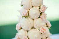 an alternative wedding cake made of meringue kisses and blush blooms is a lovely wedding dessert idea to rock