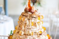 an amazing pavlova wedding cake with citrus slices and fresh fruits plus some caramel on top for a fall wedding