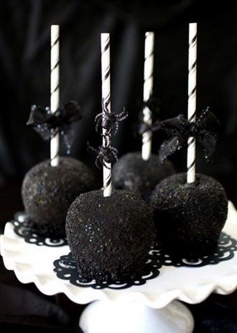 apples covered with black and on sticks with glitter spiders are lovely and chic Halloween favors