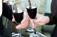 black drinks in glasses with black and white ribbon bows and black sugar rock candies