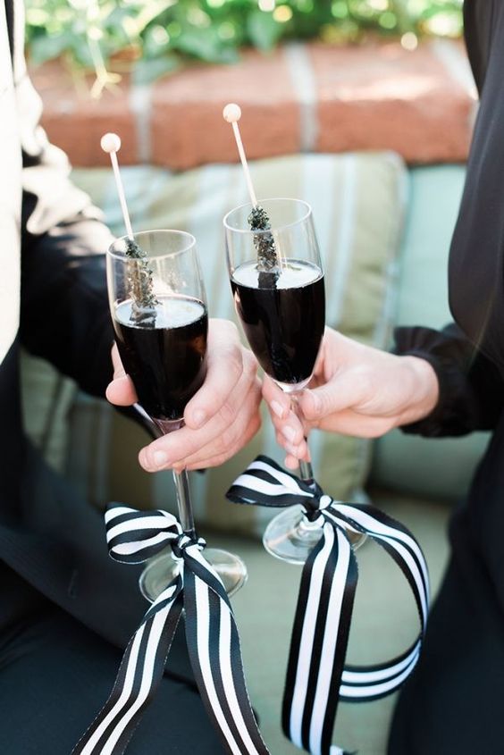 black drinks in glasses with black and white ribbon bows and black sugar rock candies