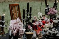 bold and chic Halloween wedding centerpiece of pink and red blooms, blush orchids, black candles in tall candleholders are amazing
