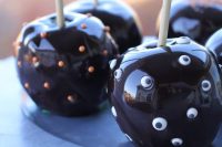 chocolate covered apples with polka dots and googly eyes are delicious wedding favors for Halloween
