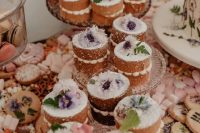 individual naked wedding cakes with sugar powder and fresh blooms and leaves for a boho wedding