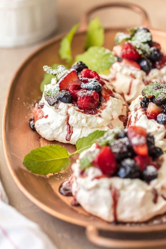 mini pavlovas with fresh berries and berry compote on top plus fresh mint for a summer wedding