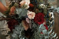 a Christmas wedding bouquet of greenery, eucalyptus, blush and burgundy blooms and privet berries is very chic