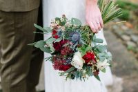 a Christmas wedding bouquet of white and burgundy blooms, thistles, berries and greenery is a chic idea