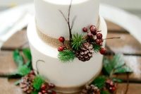 a Christmas wedding cake with burlap ribbons, pinecones, twigs, berries is ideal for a holiday wedding