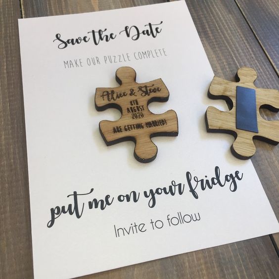 a black and white save the date with a wooden puzzle piece and black calligraphy is a catchy and stylish idea for a whimsy wedding