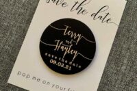 a black and white save the date with black calligraphy, a black round magnet with a save the date is a lvoely idea for a modern wedding