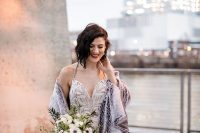 a blush sheath wedding dress with a fully embellished patterned bodice, spaghetti straps and a grey faux fur coverup