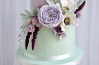 a bold mint and lavender wedding cake decorated with white, blush, purple and lavender sugar blooms and greenery