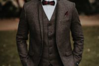 a brown plaid tweed three-piece suit, a white button down, a burgundy bow tie for an elegant winter look