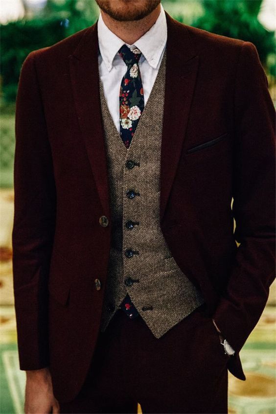 a burgundy velvet suit, a brown tweed waistcoat, a white button down, a moody floral tie for a winter look with a touch of boho