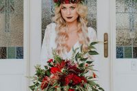 a colorful Christmas wedding bouquet of red and burgundy blooms, greenery and matching red ribbons is amazing