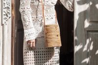 a crochet fitting wedding dress with various patterns, with a V-neckline and long sleeves plus a woven bag for a boho summer bride