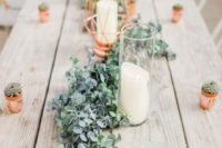 a cute greenery and foliage table garland with candles and copper candle holders