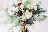 a frozen Christmas wedding bouquet of white and blue blooms, greenery and fir plus burgundy velvet ribbons