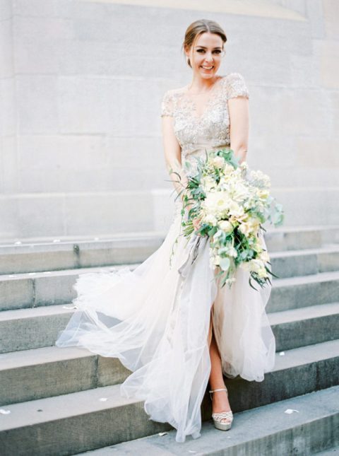 a glam wedding dress with silver embellished illusion bodice, short sleeves and a layered skirt with a slit