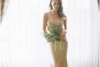 a gold sequin sheath wedding dress with a scoop neckline, cap sleeves and a train is a chic modern idea to rock