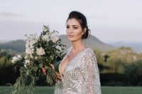 a gorgeous modern wedding dress with a nude underdress, wide sleeves and a plunging neckline and large sequins