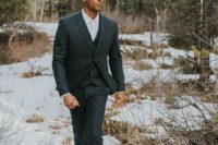 a grey tweed three-piece suit, a white shirt and a tie plus brown boots for a winter wedding