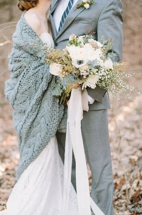 a large cable knit grey coverup matches the groom's suit and keeps the bride warm