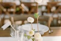 a lovely modern cluster wedding centerpiece of a couple of candles and white dahlias in a vase is a chic idea that you may realize yourself