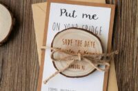 a lovely rustic wedding save the date of a tree slice and wood burning, with yarn and a kraft paper envelope