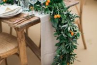 a lush greenery garland with some kumquats is a gorgeous idea for a modern or all-natural and rustic wedding